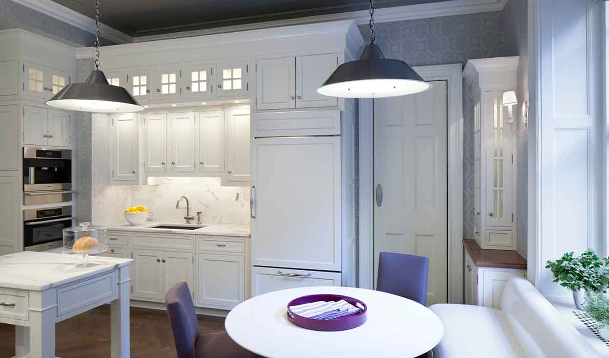 Modern kitchen with sleek white cabinetry, marble countertops, and contemporary lighting at 390 West End Avenue apartments in NYC. Renovation by Universal Management & Contracting Corp.