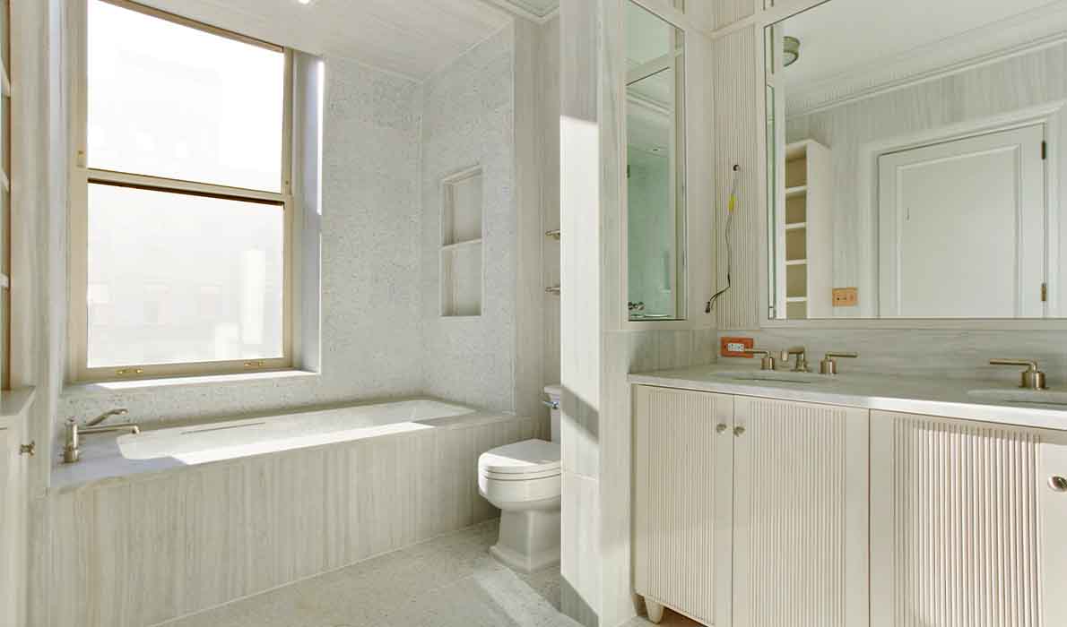 Modern luxury bathroom renovation at 390 West End Avenue apartments in NYC, featuring marble finishes, custom cabinetry, and high-end fixtures completed by Universal Management & Contracting Corp, a New York City construction company specializing in residential remodeling.