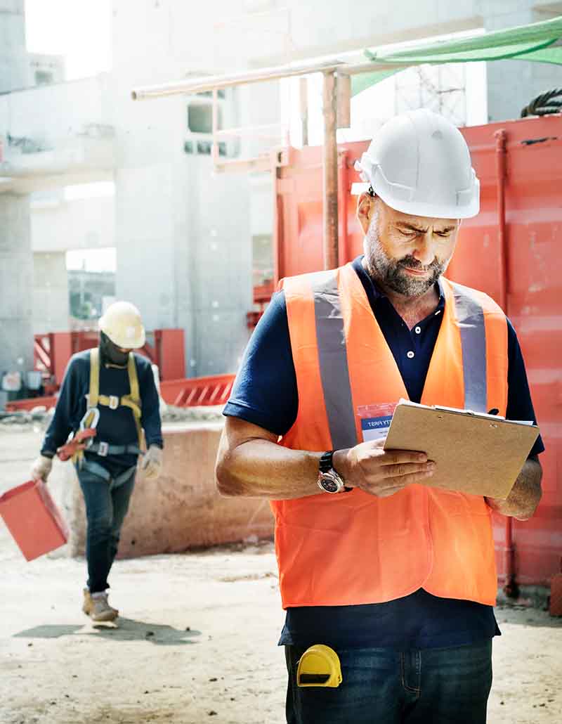 Construction project manager reviewing job site plans and coordinating contractors in New York City