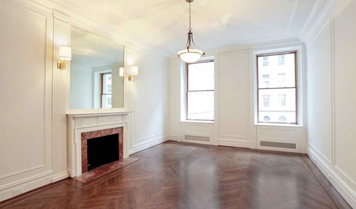 Elegant dining room renovation at 390 West End Ave apartments in NYC by Universal Management & Contracting Corp, featuring custom millwork, hardwood herringbone floors, and decorative fireplace design.
