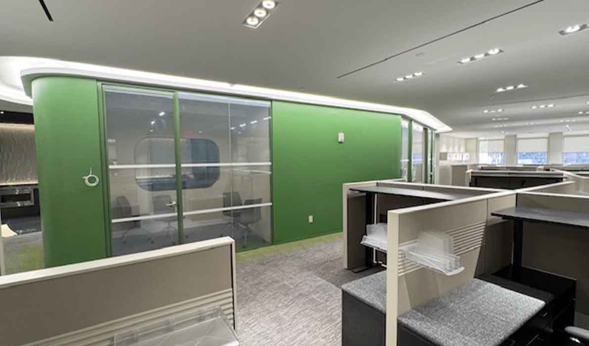 Modern office interior with green accent wall and glass partitions by Universal Management in NYC