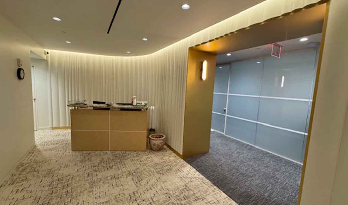 Modern office lobby interior with reception desk and glass wall designed by Universal Management in NYC