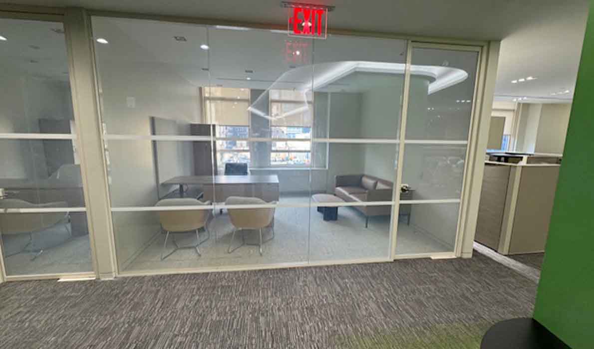 Glass-walled conference room in a modern NYC office built by Universal Management, showcasing high-end commercial construction and interior design.
